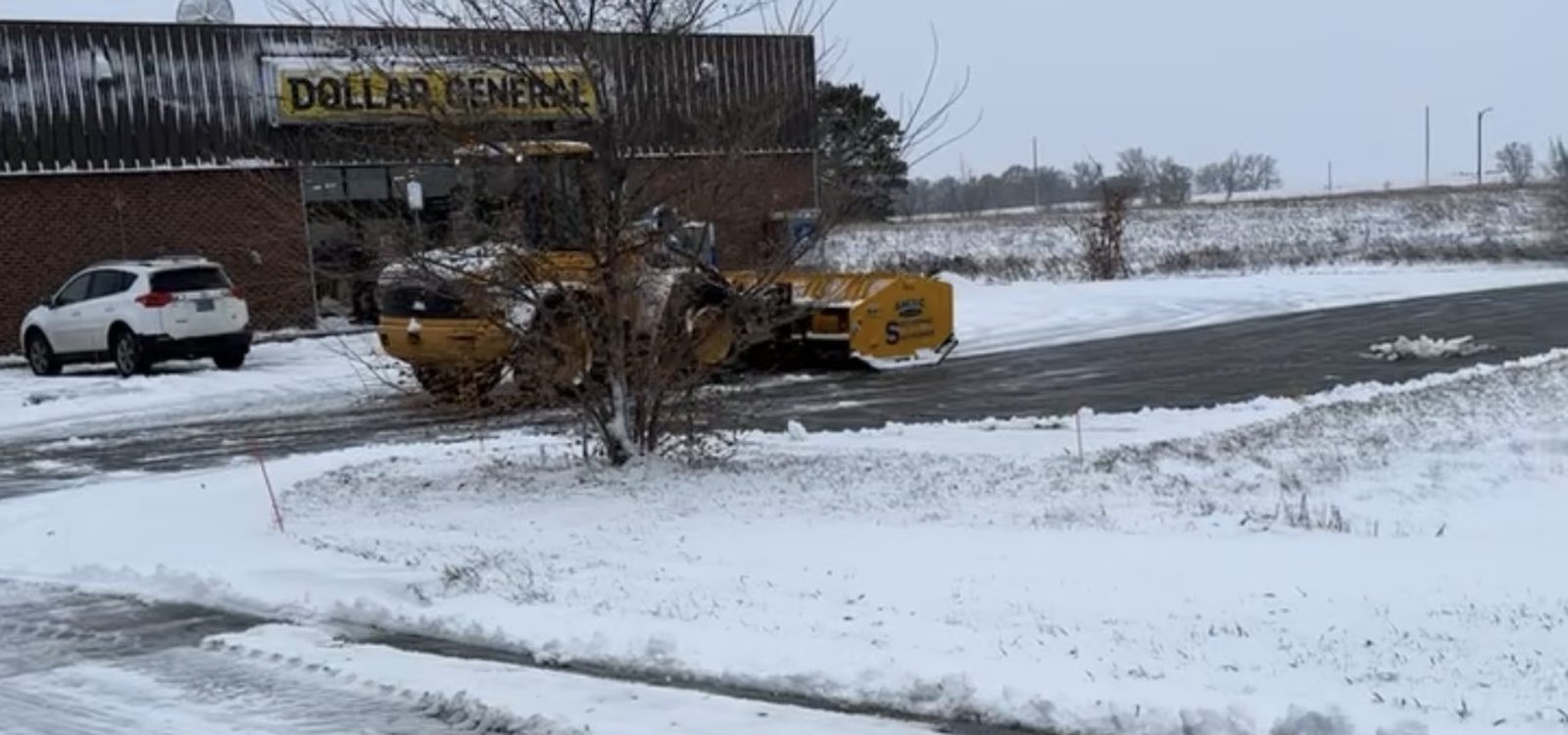 Stormworthy loader and sectional pusher clearing a retail parking lot in Bismarck, ND
