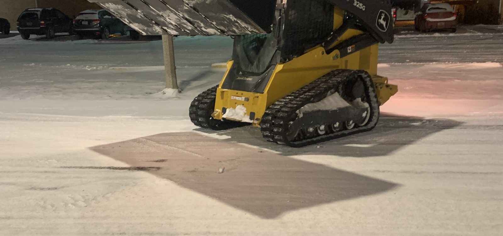 Stormworthy track loader on a cleared and treated apartment lot at night